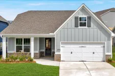 Thumbnail for Modern single-story gray house with white garage door, front porch, and green lawn under blue sky