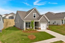Thumbnail for Modern single-family home with gray siding, garage, and manicured lawn on a sunny day with blue sky.