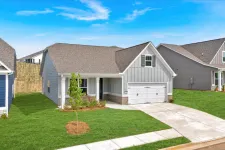 Thumbnail for Modern single-story gray house with a two-car garage and green lawn under a blue sky.