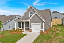 Thumbnail for Modern gray house with a front porch, single garage, and landscaped yard under a blue sky.
