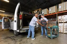 Thumbnail for a couple of men standing next to a van in a warehouse