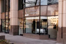 Thumbnail for Office building exterior with large windows showing Exit Stage Left Advisors signage and a person working inside.