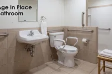 Thumbnail for Accessible bathroom with grab bars, raised toilet with armrests, and wall-mounted sink for age-friendly design.