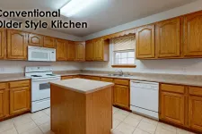 Thumbnail for Traditional kitchen with oak wood cabinets, white appliances, tiled floor, and a central island under fluorescent light.