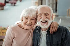 Thumbnail for Happy elderly couple smiling outdoors with arm around each other, showing warmth and companionship.