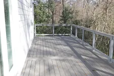 Thumbnail for a wooden deck with a railing and trees on the side