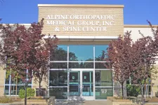 Thumbnail for Front entrance of Alpine Orthopaedic Medical Group and Spine Center building with trees and clear sky.