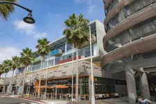 Thumbnail for a building with palm trees and a street