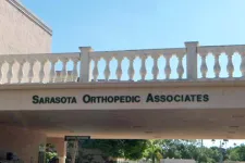 Thumbnail for Exterior entrance of Sarasota Orthopedic Associates medical office under a balcony with balustrade.