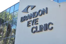 Thumbnail for Exterior view of Brandon Eye Clinic building with reflective windows and eye logo on white wall.
