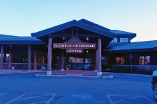 Thumbnail for Entrance of Flathead Orthopedic Center with wooden beams and stone accents at dusk