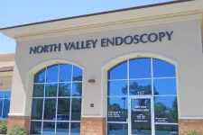 Thumbnail for Front exterior of North Valley Endoscopy Center with large windows and entrance door under clear blue sky.