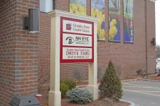 Thumbnail for Outdoor sign for Granite State Credit Union and NH Eye Associates with drive-thru directions in parking lot area.
