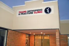 Thumbnail for Entrance of Tigard Orthopedic and Fracture Clinic with illuminated sign and brick facade in the evening.