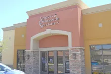 Thumbnail for Entrance of Sports & Orthopaedic Specialists clinic with brick pillars and glass doors under clear sky