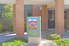 Thumbnail for Outdoor sign for The Ambulatory Surgi-Center with flowers and mountain logo in front of brick building entrance.