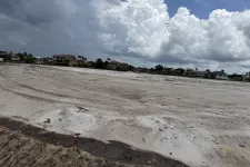 Thumbnail for Cleared sandy construction site in a residential neighborhood under cloudy skies