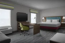 Thumbnail for Modern hotel room with king bed, wooden desk, green swivel chair, TV, and natural light from two windows.
