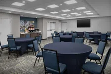 Thumbnail for Modern conference room with round tables covered in dark cloths and blue chairs under bright ceiling lights