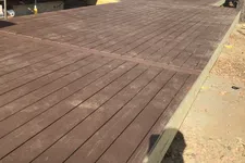 Thumbnail for Newly constructed elevated wooden deck attached to a log cabin with nearby parking and trees.