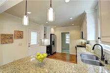 Thumbnail for Modern kitchen with granite countertops, stainless steel appliances, pendant lighting, and hardwood floors.