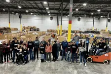 Thumbnail for a group of people posing for a photo in a warehouse