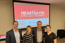 Thumbnail for Bill Koman et al. posing for a photo in front of a large screen