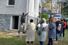 Thumbnail for a group of people standing outside a house