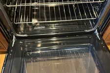 Thumbnail for Open clean oven with two metal racks and Easy Wash removable tray inside a kitchen appliance.