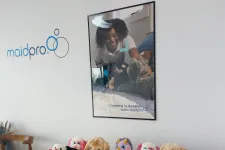 Thumbnail for Variety of colorful stuffed animals displayed on a table under a MaidPro cleaning services poster and logo on the wall.