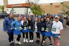 Thumbnail for Group of women wearing blue tutus and race bibs standing together outdoors before a race event under cloudy sky.