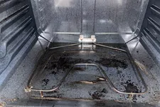 Thumbnail for Dirty oven interior with visible grease stains and heating element at the bottom, showing need for cleaning.