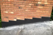 Thumbnail for a brick wall with a black grate in front of it