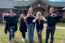 Thumbnail for a group of people posing for a photo in front of a house