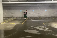 Thumbnail for a man holding a broom in a parking garage