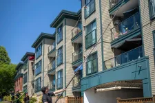 Thumbnail for a person standing in front of a row of houses