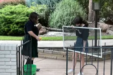 Thumbnail for a couple of girls standing on a metal fence