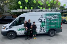 Thumbnail for a group of people posing for a photo in front of a van