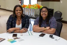 Thumbnail for a couple of women sitting at a table with a card and a phone