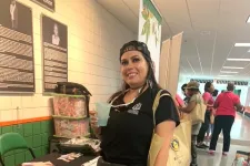 Thumbnail for Smiling woman in black outfit holding drink at a Florida A&M University Medical Marijuana research booth.