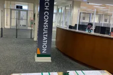 Thumbnail for Research consultation area in a modern office with information desk, brochures, and glass partitions.