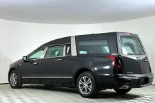 Thumbnail for Black luxury Cadillac hearse with extended rear cargo area parked in white studio environment
