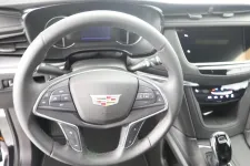 Thumbnail for Close-up of a Cadillac steering wheel and dashboard with modern controls and sleek design.