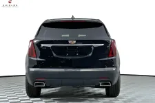 Thumbnail for Rear view of a black Cadillac SUV on a checkered floor backdrop, showcasing its sleek design and modern features.