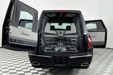 Thumbnail for Rear view of a black MasterCoach hearse with open doors revealing interior coffin holders and luxury detailing.