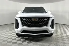 Thumbnail for Front view of a white Cadillac SUV with a black grille and emblem in a photo studio.