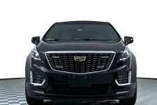 Thumbnail for Front view of a sleek black Cadillac SUV with distinctive grille and modern design.