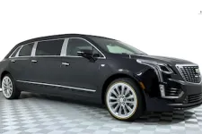 Thumbnail for Sleek black Cadillac crossover SUV with premium wheels and elegant design on a checkered floor.