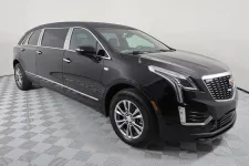 Thumbnail for Sleek black Cadillac SUV with elegant lines, showcased on a patterned floor backdrop.