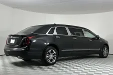 Thumbnail for Sleek black Cadillac limousine parked in a modern studio with illuminated background.